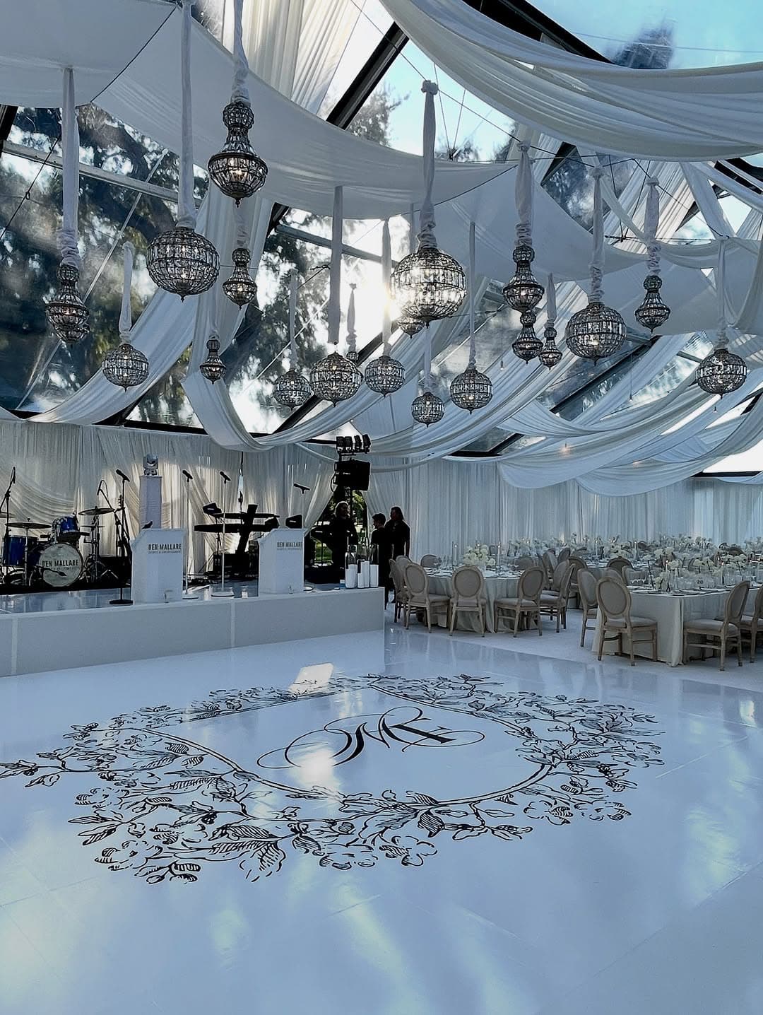 Elegant white monogram dance floor with wreath design in luxury venue with chandeliers