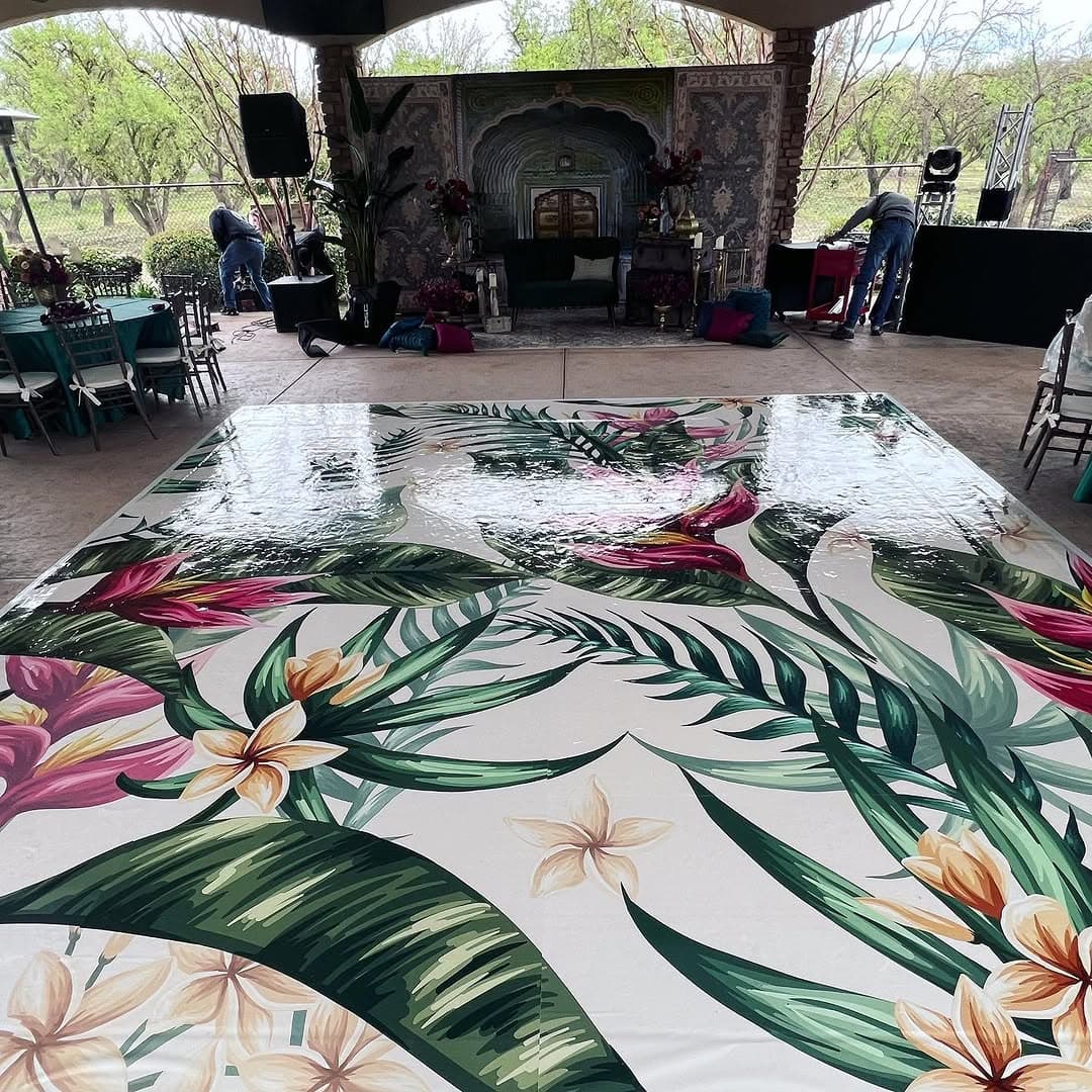 Wide view of a tropical floral dance floor rental in an outdoor pavilion