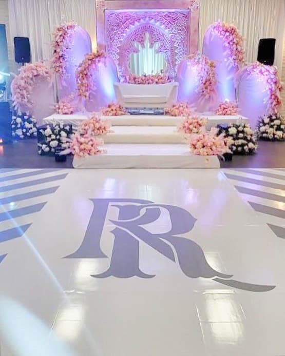 White dance floor rental with a large printed script monogram at the centre